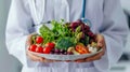 Person in White Coat Holding Plate of Vegetables Royalty Free Stock Photo