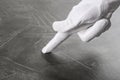 Person in white glove checking cleanliness of grey table