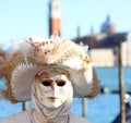 person in a white mask with an unrecognizable face at Venice Carnival in Italy with historic Church of St George Royalty Free Stock Photo