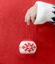 Person in winter sweater holding Christmas balls in hand. Royalty Free Stock Photo