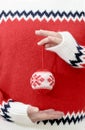 Person in winter sweater holding Christmas balls in hands. Royalty Free Stock Photo