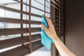 Person wiping window blinds using microfiber cloth Royalty Free Stock Photo