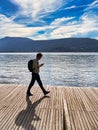 person on wooden board walk of mountain lake