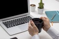 Person working with computer on desk. Holding coffee in hand Royalty Free Stock Photo