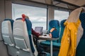 Person working on a laptop computer while commuting with a train. Worker commuter doing some job on the move. Colorful train