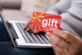 Person Working On Laptop Holding Gift Card Royalty Free Stock Photo