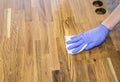 Person working rubbing oiling with linseed oil natural wooden kitchen countertop before using. Solid wood butcher block.