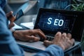Person working on SEO strategy on a laptop, analyzing data and optimizing website performance in a professional setting
