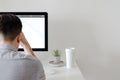 A person working with serious expression at office with personal computer screen that have a coffee and tillandsia air plant with Royalty Free Stock Photo