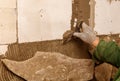 A person is working on a wall, using a trowel to apply a layer of plaster Royalty Free Stock Photo