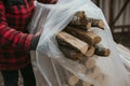 person wrapping a bundle of wood in plastic sheeting Royalty Free Stock Photo