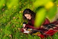 Person writes notes lying on the lawn in the autumn park. Solitude with yourself