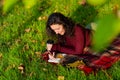 Person writes notes lying on the lawn in the autumn park. Solitude with yourself