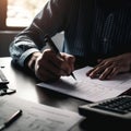 Person Writing Financial Calculations and Notes for Symbolizing the Importance of Record-Keeping and Analysis in Finance