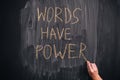 Person writing phrase Words Have Power on a blackboard