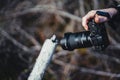 Person's hand holding a photo camera against a blurry nature background. Royalty Free Stock Photo