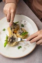 Of a person& x27;s hands holding a fork and knife while sampling a plate of freshly cooked pancakes