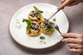 Of a person's hands holding a fork and knife while sampling a plate of freshly cooked pancakes