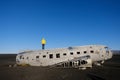 Wide shot of a crashed airplane with a person in a yellow hoodie standing on top