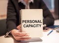 PERSONAL CAPACITY inscription on a notepad in businesswoman hand Royalty Free Stock Photo