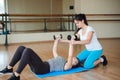 Personal coach helping woman to do exercises with dumbbells in gym. Royalty Free Stock Photo