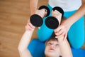 Personal coach helping woman to do exercises with dumbbells in gym. Royalty Free Stock Photo