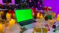 Personal computer with a chroma key on the screen lies on the New Year\'s table. Freelancer\'s Christmas workplace.