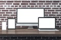 Personal computer, digital tablet, smartphone and laptop with blank screen on brick wall background Royalty Free Stock Photo