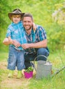 Personal example. Little helper in garden. Planting flowers. Growing plants. Take care of plants. Boy and father in