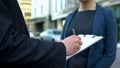 Personal female assistant waiting while male boss signing contract near office Royalty Free Stock Photo