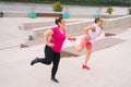Personal fitness female trainer helping fat woman lose weight outside taking step exercising on city stairs in summer Royalty Free Stock Photo
