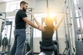 Personal fitness trainer coaching and helping client woman making exercise in gym. Sport, teamwork, training, people concept Royalty Free Stock Photo