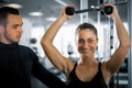 Personal fitness trainer with his client in gym.