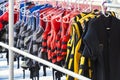 Personal flotation device as a life jacket in store. Many bright life jackets hang in a row on hangers Royalty Free Stock Photo