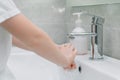 Personal hygiene. Child washes hands a small with soap over the sink with running water Royalty Free Stock Photo