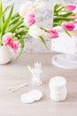 Personal hygiene, cleanliness and skin care. Cotton pads and swabs in a glass on a table in front of a mirror and tulips Royalty Free Stock Photo