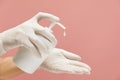Personal Hygiene. Hands In White Gloves With Bottle Of Soap On Pink Background. Daily Routine With Antibacterial Products. Royalty Free Stock Photo
