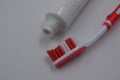 Personal hygiene products, a new plastic toothbrush with red and white bristles, with red rubber inserts and toothpaste Royalty Free Stock Photo