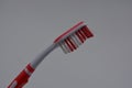 Personal hygiene products, a new plastic toothbrush with red and white bristles, with red rubber inserts and toothpaste Royalty Free Stock Photo