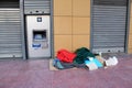 Personal items of homeless person next to ATM machine in the center of Athens