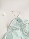 Personal music phone accessory. White headphones with wires on the blue textural background