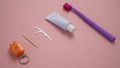 Personal oral hygiene product on a pink background. Toothbrush tube toothpaste toothpick and floss. Flat lay Royalty Free Stock Photo