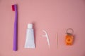 Personal oral hygiene product on a pink background. Toothbrush tube toothpaste toothpick and floss. Flat lay Royalty Free Stock Photo