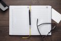 Personal organizer and pen with glasses on the table Royalty Free Stock Photo