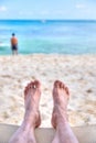 Personal perspective of man relaxing at beach with feet view Royalty Free Stock Photo