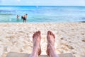 Personal perspective of man relaxing at beach with feet view Royalty Free Stock Photo