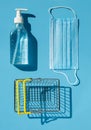 Personal protection kit for shopping during the coronavirus pandemic: face mask, gel sanitizer and shopping basket. Royalty Free Stock Photo