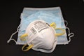 N95 Respirator and pile of surgical masks Royalty Free Stock Photo