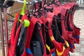 Personal red life jackets in store. Many life jackets hang in a row on hangers. Protective safety clothing at rental boat store or Royalty Free Stock Photo