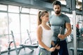 Personal trainer assisting beautiful woman lose weight